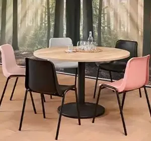 Kantinestoelen in verschillende kleuren rondom een ronde tafel in een sfeervolle kantine-inrichting